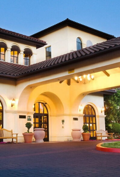 Hotel entrance with arched architecture and landscaped surroundings