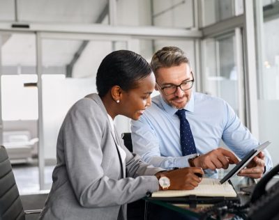 Business woman and man looking at information on a tablet