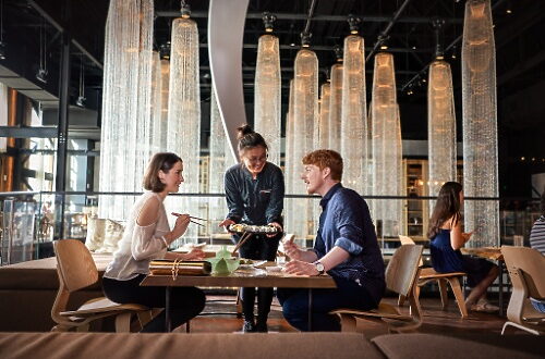 black astromech droid in a hanger in front of storm toopers