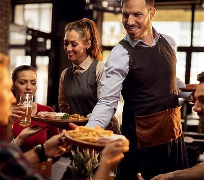 Waiter serving food to someone