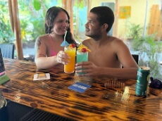 Guests toasting colorful tropical cocktails at Hidden Oasis Tiki Bar