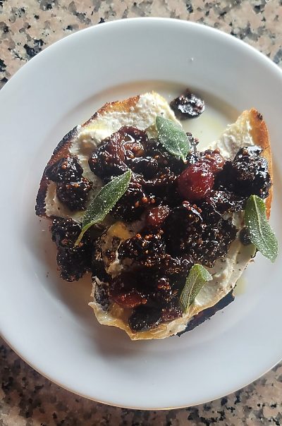 Gourmet toast with figs, cream cheese, and sage garnish