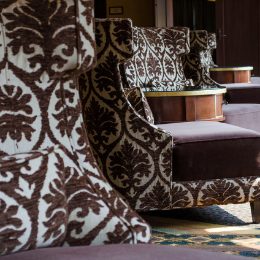 Luxurious lounge area with intricately patterned upholstery and wooden accents, offering a comfortable and elegant ambiance.