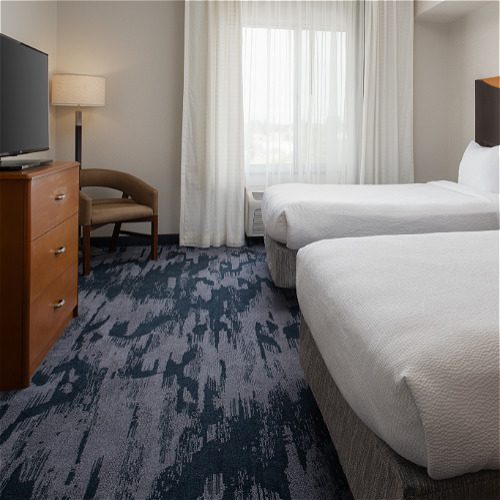 hotel room with two beds, TV and chair