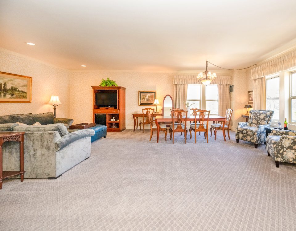 a hotel room with a sitting area, dining area, and two chairs