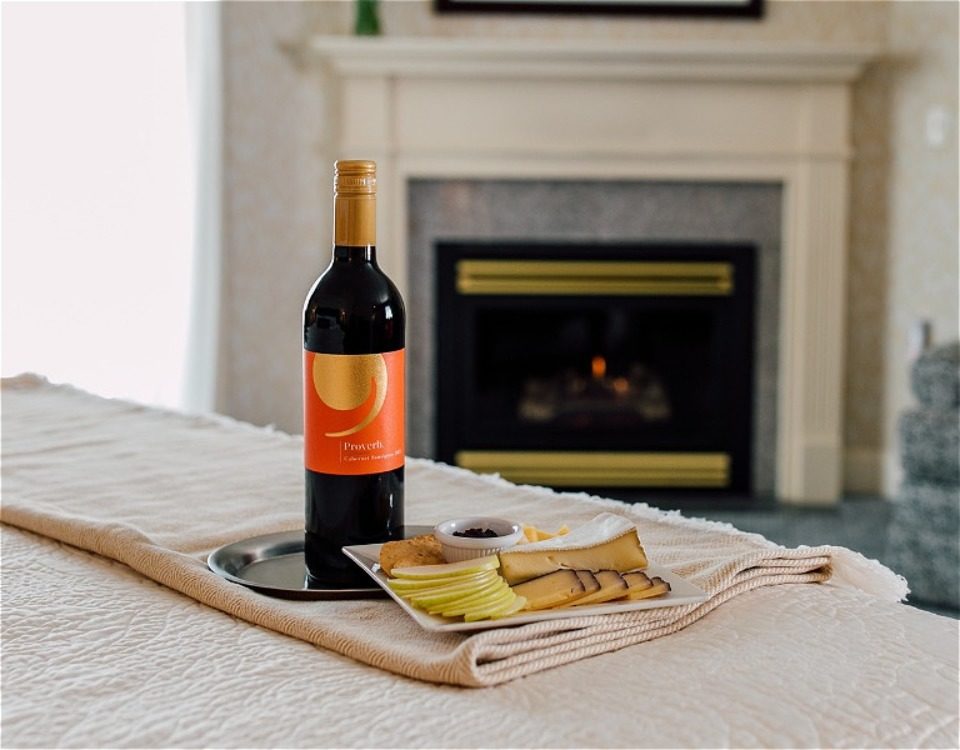 Bottle of wine and hceese by fireplace