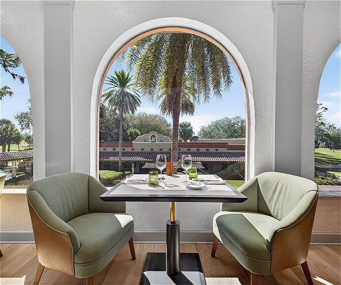 Dining table with window looking out to palm trees loading=