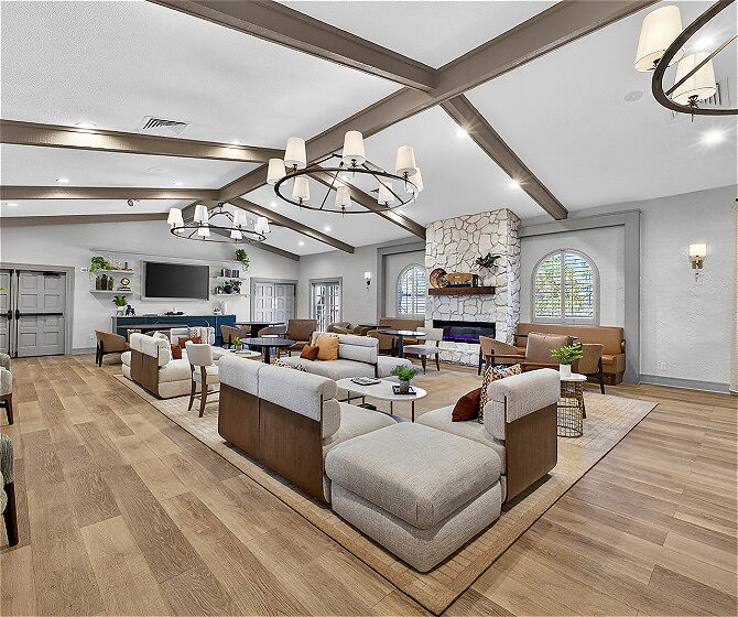 Large room with hardwood floors, chandeliers, and white couches loading=