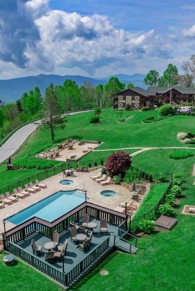 Grassy hill with buildong and outdoor pool
