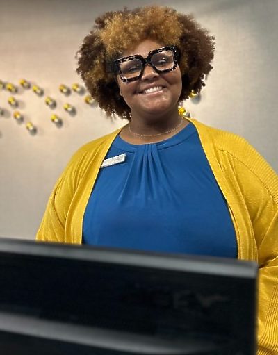 A young woman smiling while working at a hotel front desk